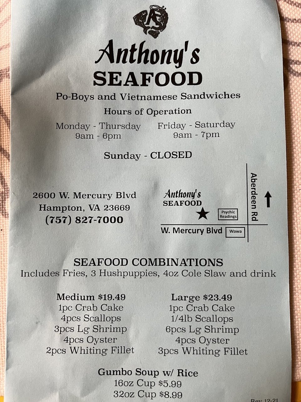 Po boy sandwich beside seafood baskets.